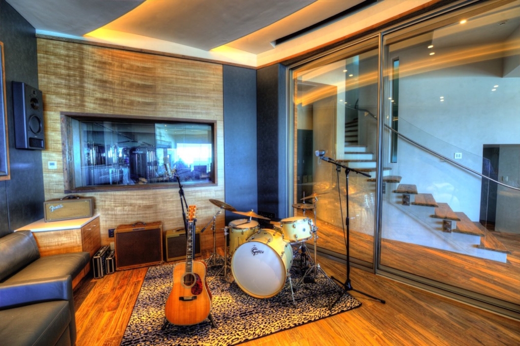 Chris Huber commissioned WSDG to design his residential private ocean-view recording studio inspired in their glass design in Diante Do Trono. Studio back with drums.